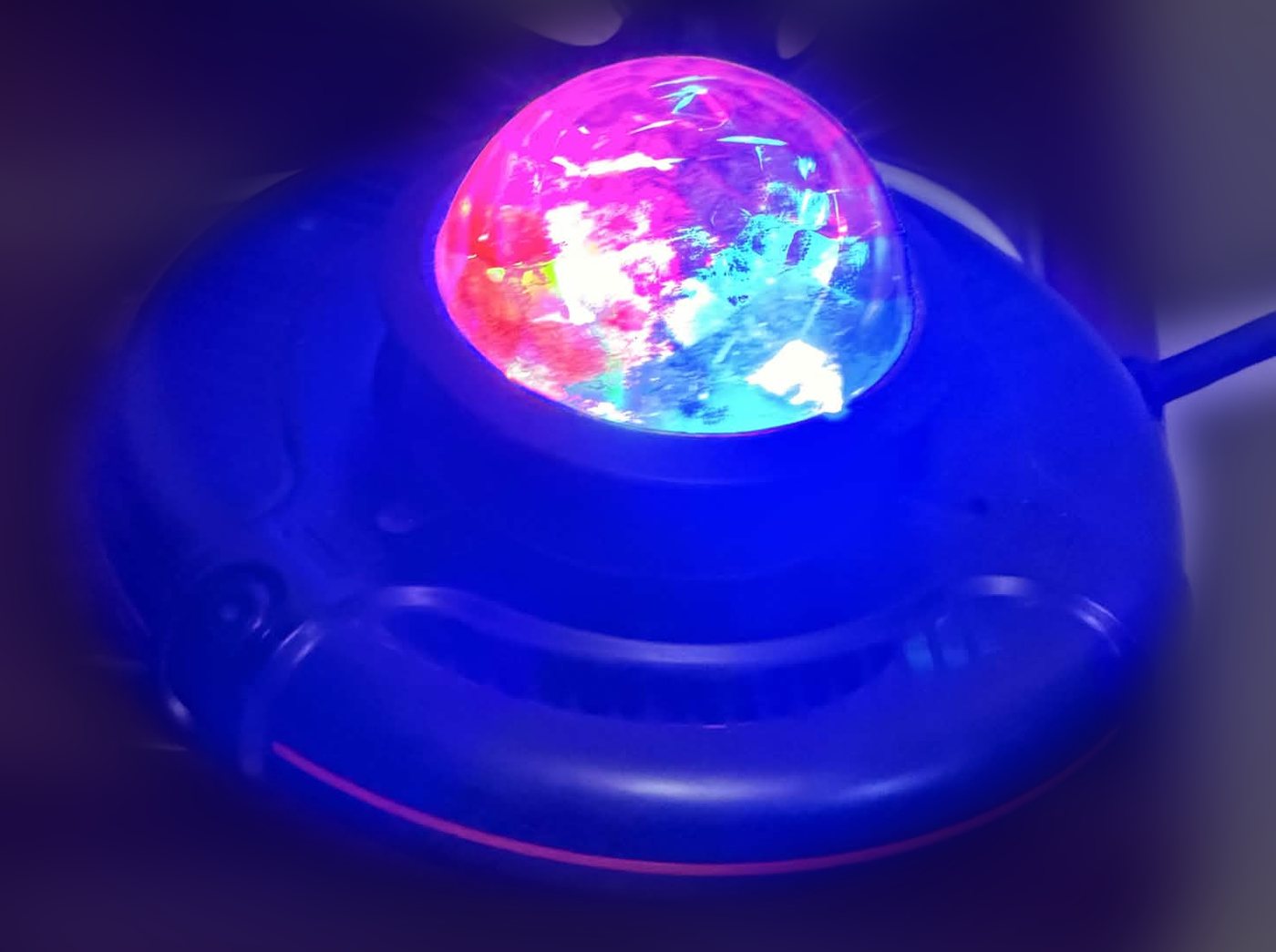 The console: a black puck with a glowing disco dome on top