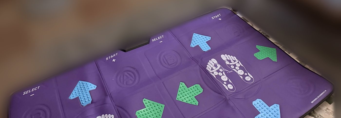 The dance mat: purple, arrows, START and SELECT pads, and a foot reflexology chart for some reason